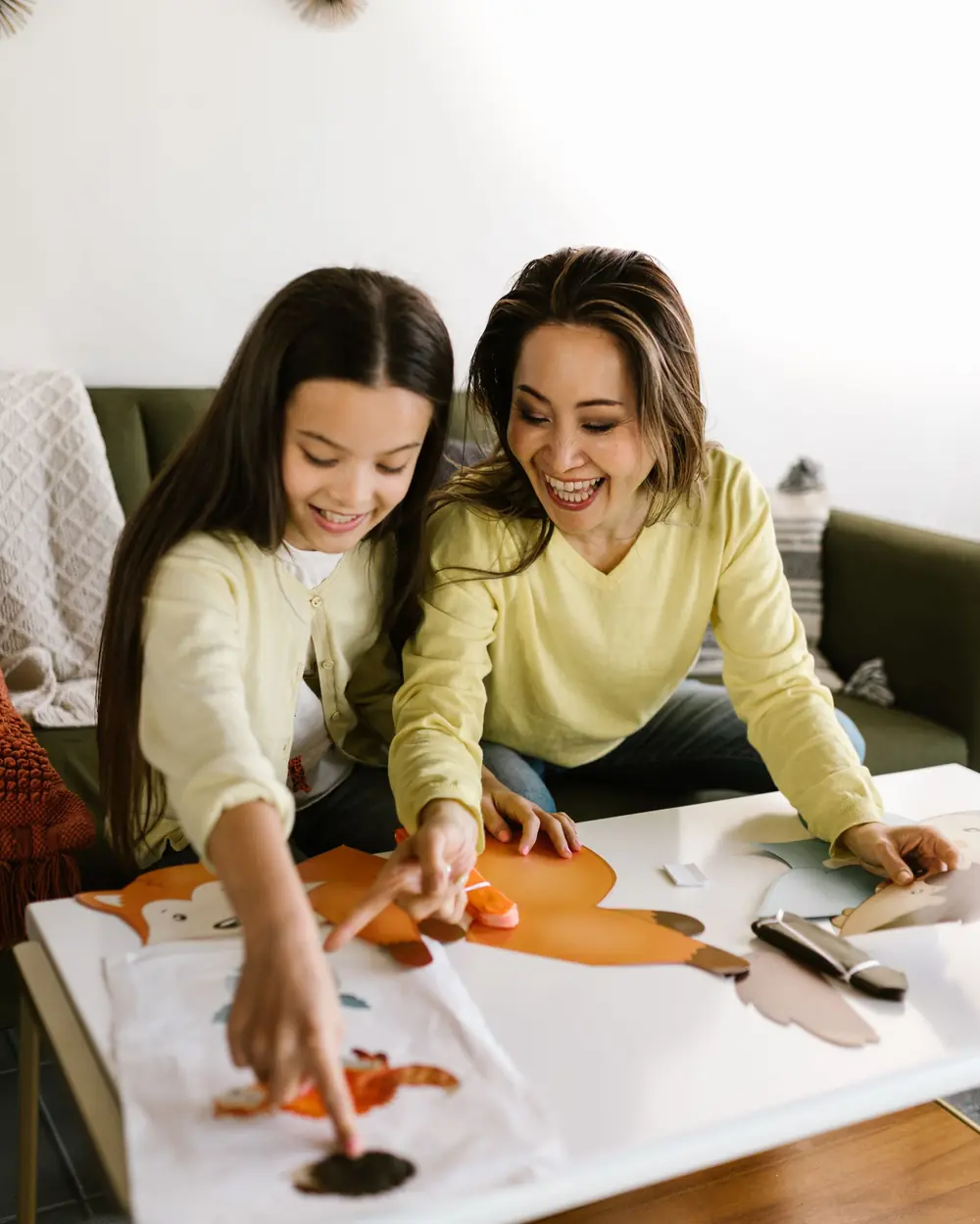 Mother and daughter painting together at a table